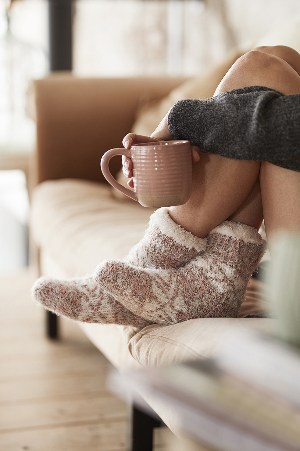 Dame geniet van haar koffie met zachte en warme huissokken